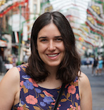 Photo of Lauren in a colourful, purple floral dress in a street in NYC